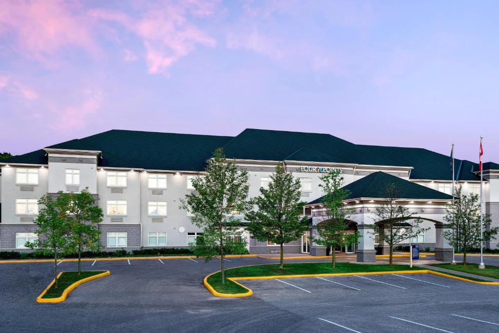 a large building with a parking lot in front of it at Four Points by Sheraton Barrie in Barrie