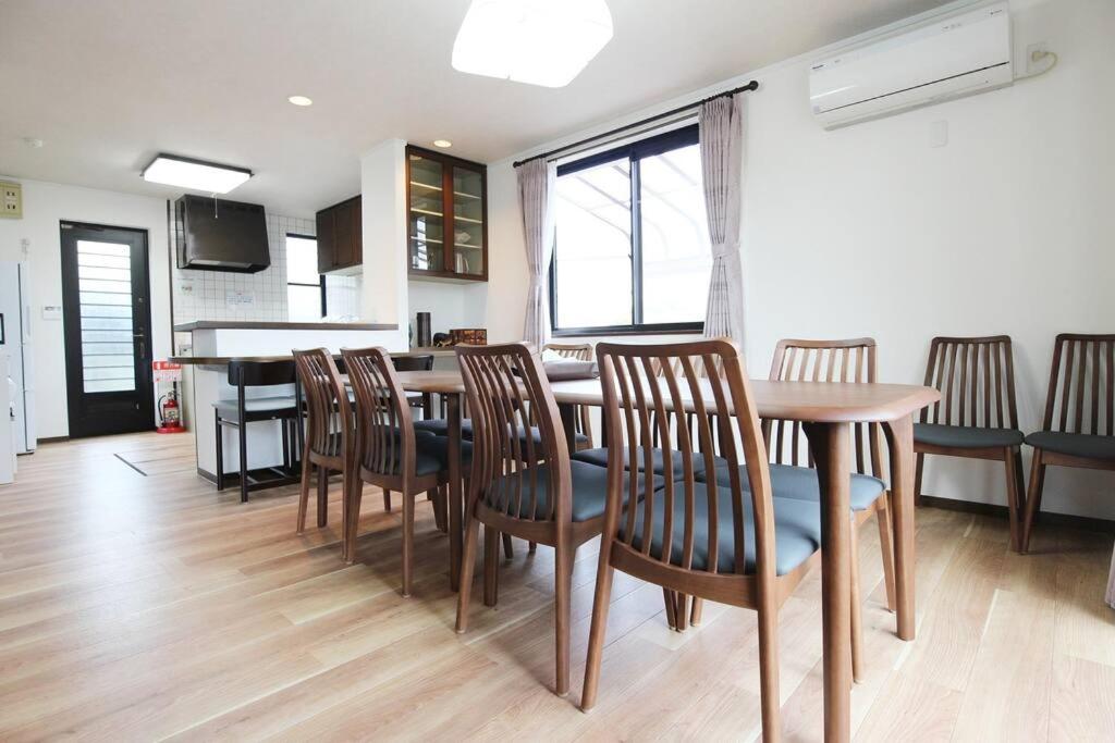 a dining room with a wooden table and chairs at 志摩の別荘 in Shima