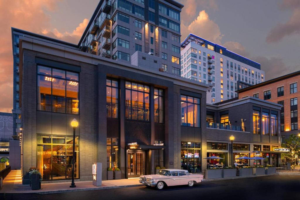 an old car parked in front of a building at The Row Hotel at Assembly Row, Autograph Collection in Somerville