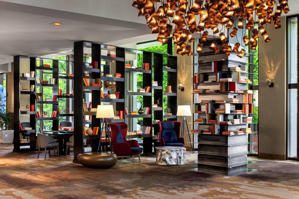 a library with bookshelves and chairs and a chandelier at Renaissance Seattle Hotel in Seattle