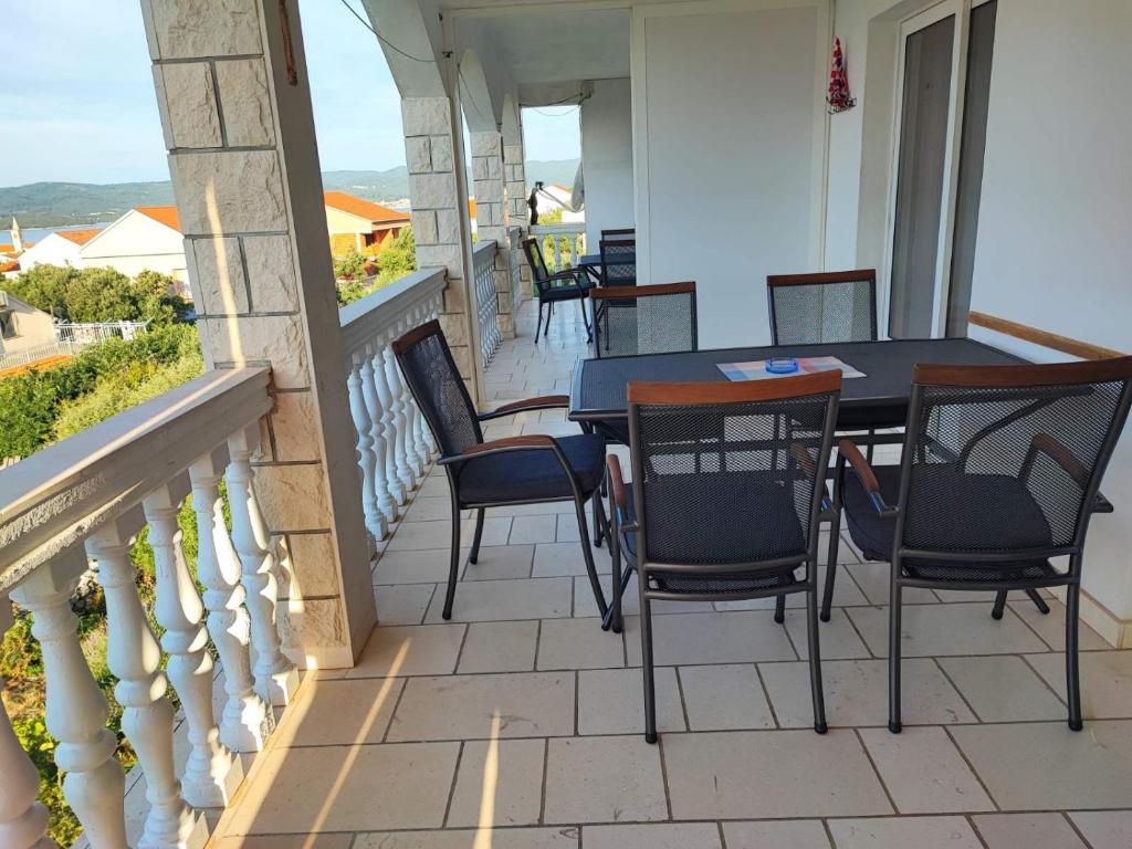 d'une terrasse avec des chaises et une table sur un balcon. dans l'établissement Apartments Dodik, à Orebić