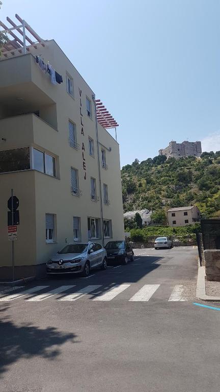 a building with two cars parked in a parking lot at Apartment Alea in Senj