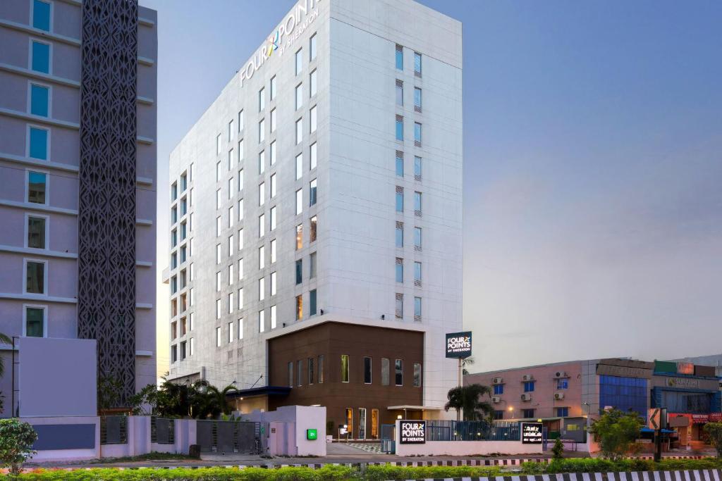 a tall white building in a city with buildings at Four Points by Sheraton Chennai OMR in Chennai