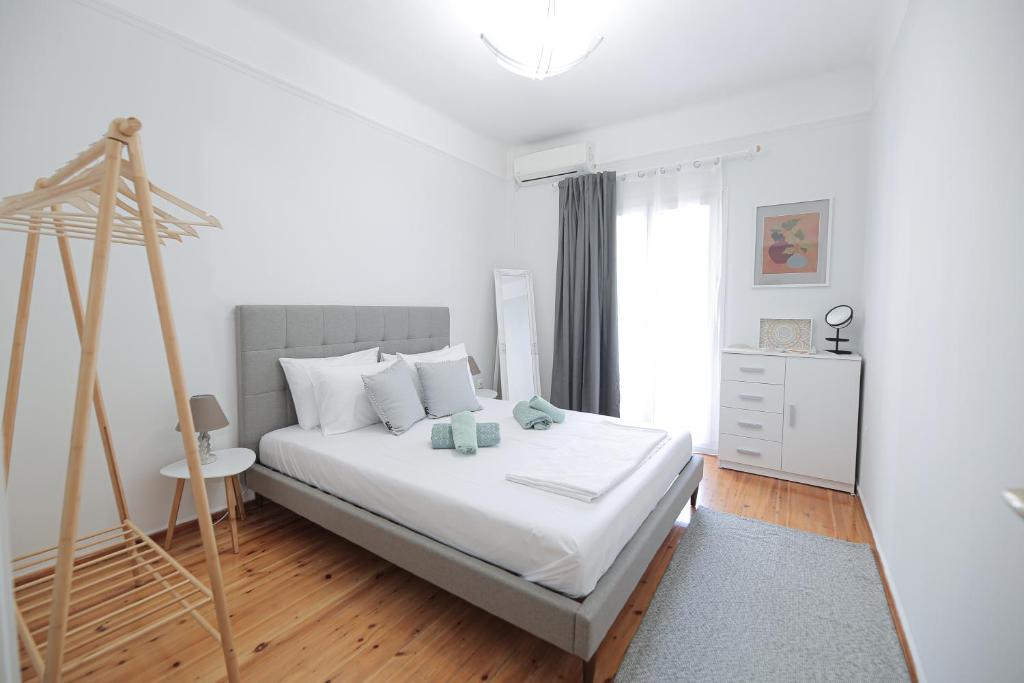 1 dormitorio blanco con 1 cama y suelo de madera en Uranus Apartment, en Tesalónica
