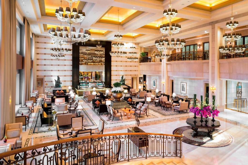 a lobby of a hotel with tables and chairs at The St. Regis Beijing in Beijing