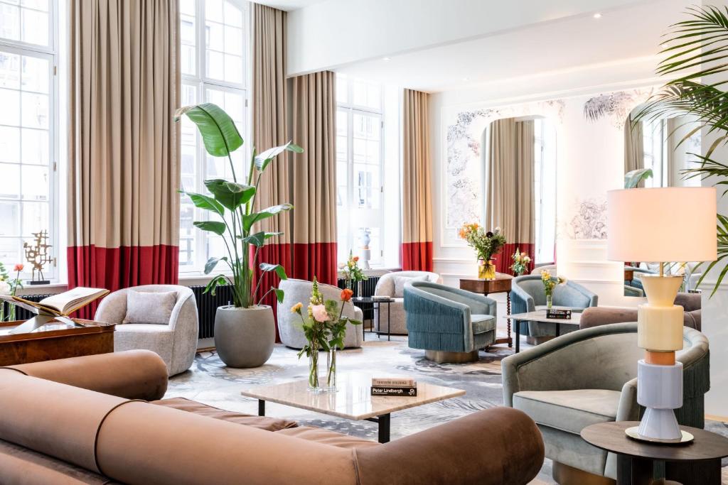 a living room with couches and tables and windows at Sapphire House Antwerp, Autograph Collection in Antwerp