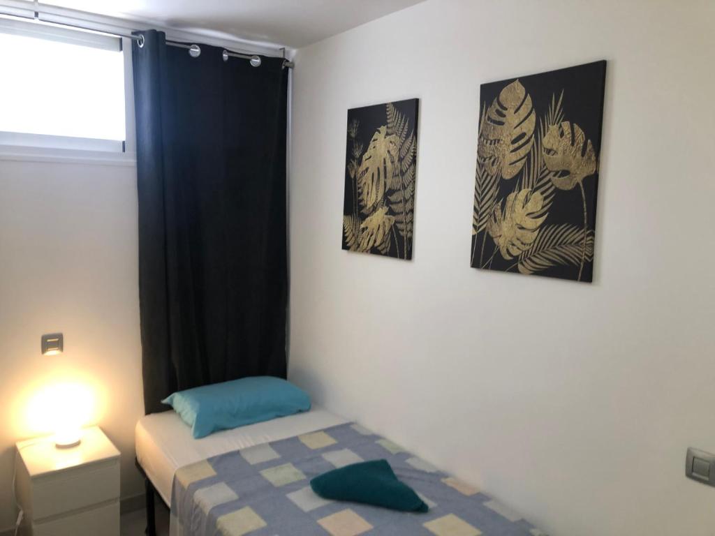 um quarto com uma cama e três fotografias na parede em ALOE Suite Laurent-Gael em Playa del Inglés