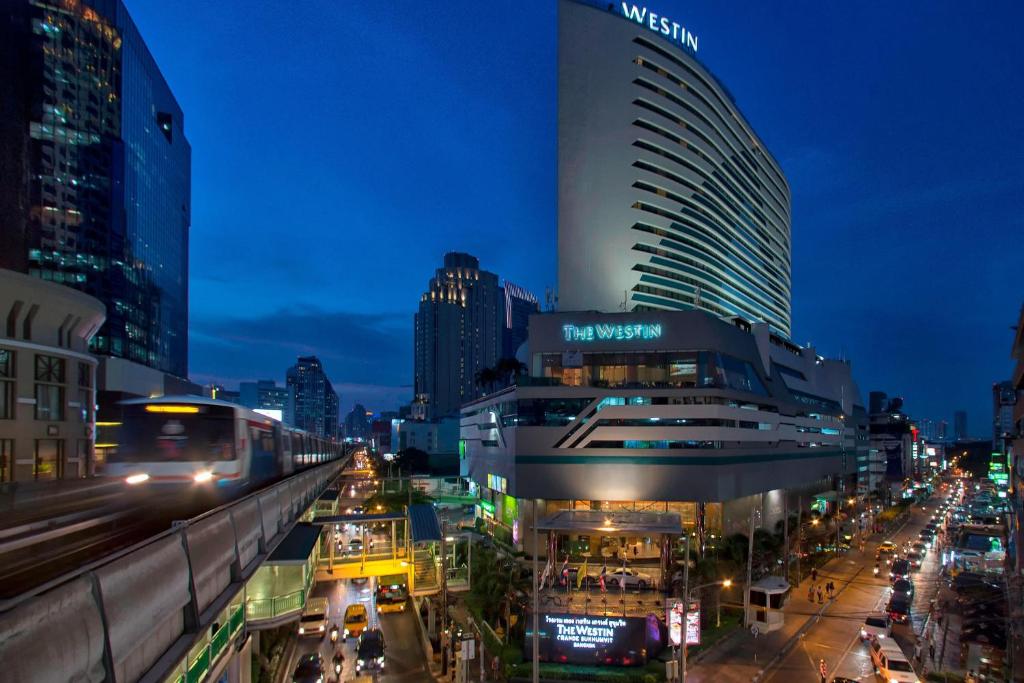 a city at night with a train on a street at The Westin Grande Sukhumvit, Bangkok in Bangkok