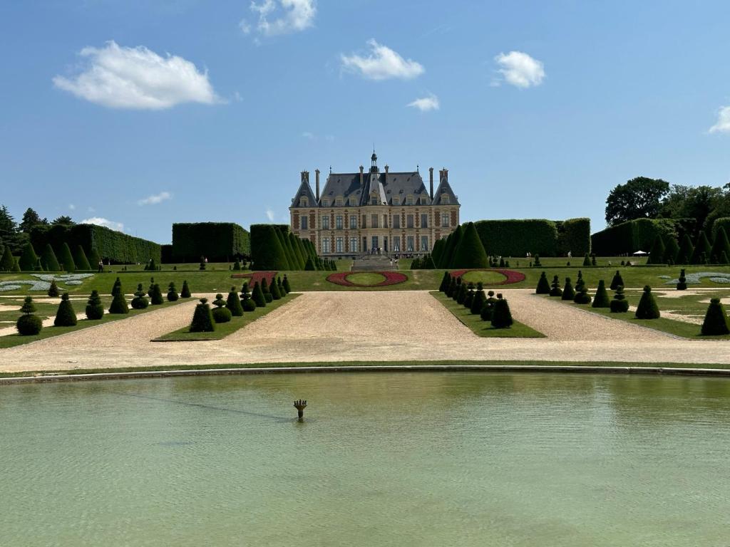 osoba w wodzie przed budynkiem w obiekcie Sceaux - Locations de Charme dans Maison w mieście Sceaux