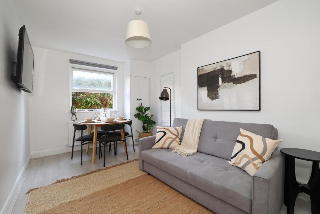 W London apt for 4. Open plan kitchen/living room في لندن: غرفة معيشة مع أريكة وطاولة