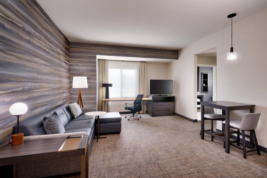 Residence Inn by Marriott Brunswick في برونزويك: غرفة معيشة مع أريكة ومكتب