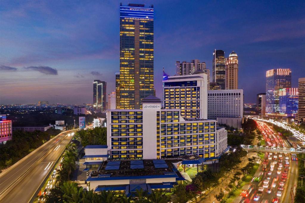 a city skyline at night with traffic on a freeway at Le Meridien Jakarta in Jakarta