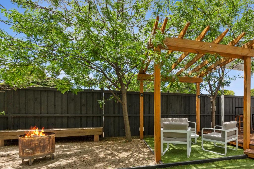 a pergola and a fire pit in a backyard at Live - Play - Stay - East Geelong in Geelong