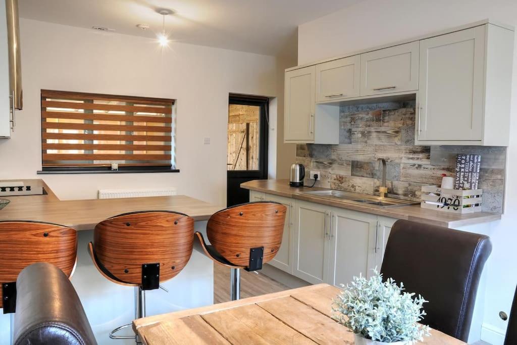 a kitchen with a table and chairs and a counter at Queensgate Holiday Cottage Beverley with Parking in Beverley