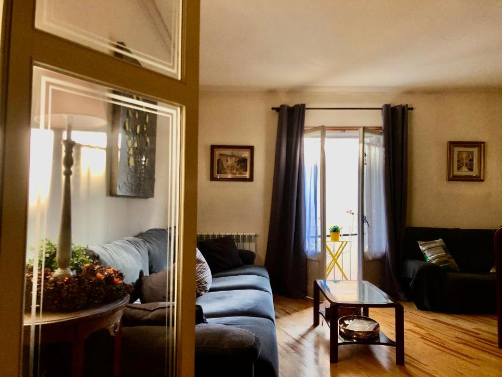 a living room with a blue couch and a table at Maison Biscuit. Apartament a la plaça de la vila in Camprodon