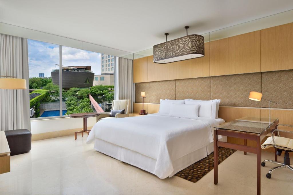 1 dormitorio con 1 cama blanca grande y escritorio en The Westin Gurgaon, New Delhi en Gurgaon