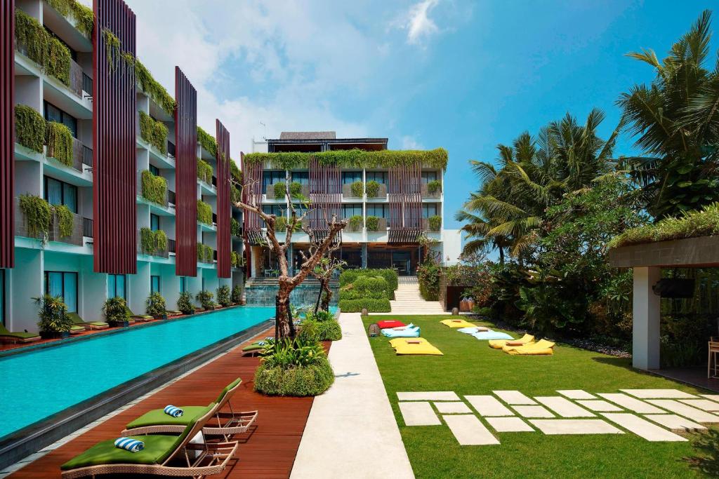 a resort with a pool and lounge chairs and a resort at Four Points by Sheraton Bali, Seminyak in Seminyak