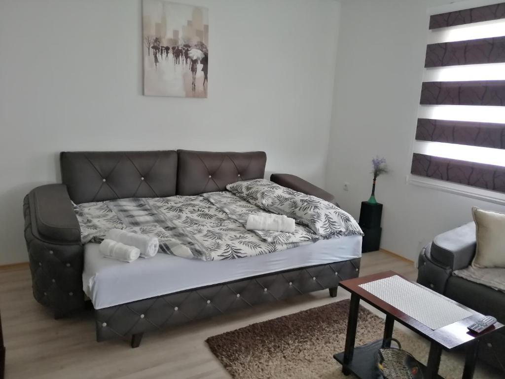 uma cama num quarto com um sofá e uma mesa em Kuća za odmor Jovana&Ivona 2023 OBRADOVIĆ SOKAK 41 em Šimanovci