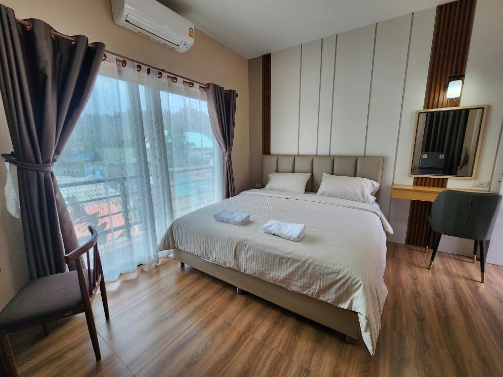 Ban Huai KrathaekにあるLeMae Residence เลอเม เรสซิเดนซ์ อำเภอเขาย้อย เพชรบุรีのベッドルーム1室(ベッド1台、大きな窓付)
