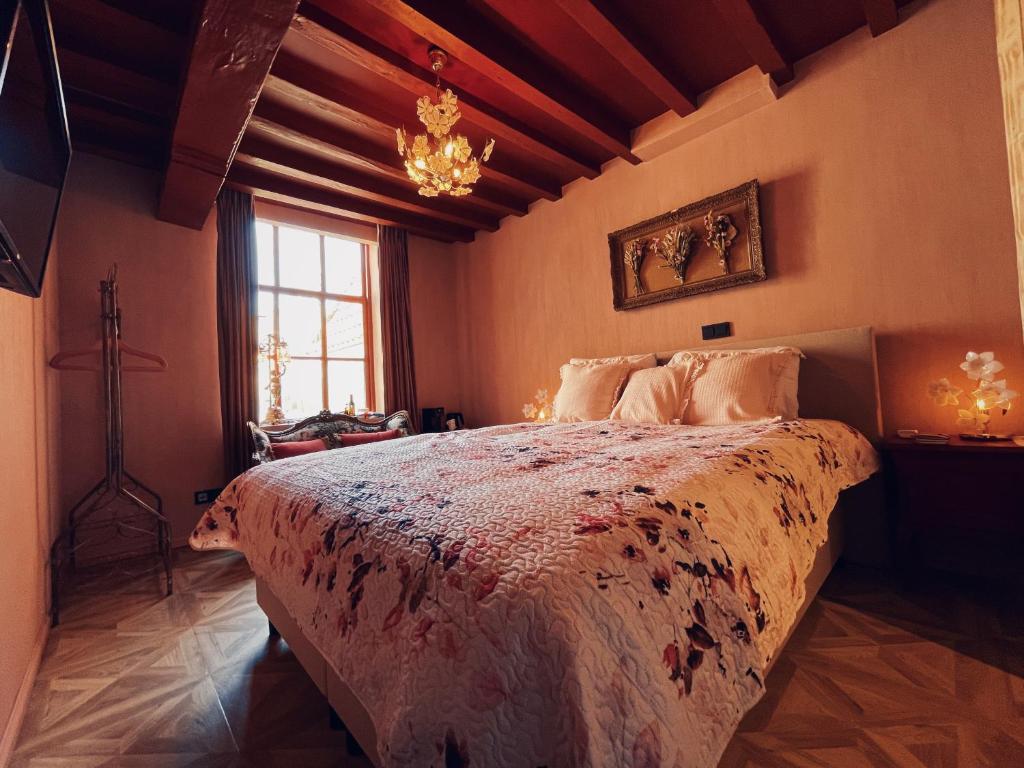 een slaapkamer met een bed en een kroonluchter bij Boutique Hotel Bajoene in Middelburg