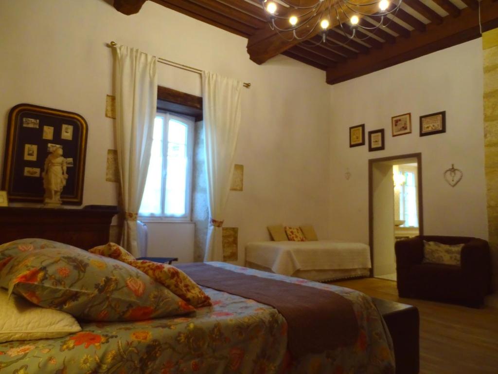 a bedroom with a bed and a window and a couch at Chambre d&#39;hôtes Au jardin de la Bachellerie in La Bachellerie