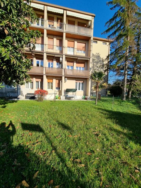 un bâtiment avec une pelouse devant lui dans l'établissement Alloggio Liberty, à Gorizia