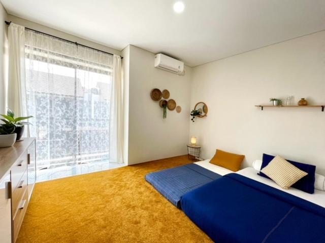 1 dormitorio con cama azul y ventana grande en Larisa Homestay Syariah 2 en Padalarang
