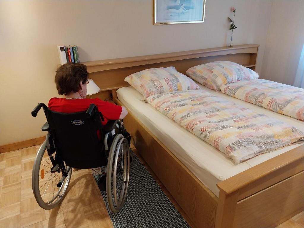 Un jeune garçon en fauteuil roulant dans une chambre dans l'établissement Rollstuhlgerechte 80m² grosse Ferienwohnung in Ostfriesland, à Utarp