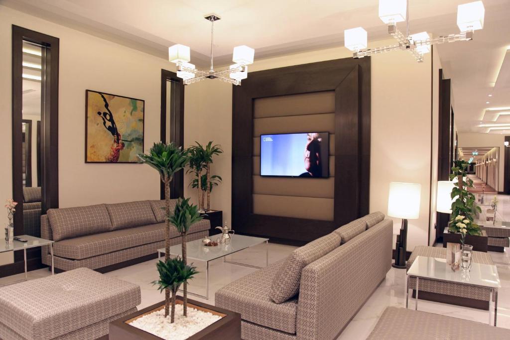 a living room with two couches and a tv at Marriott Executive Apartments Madinah in Al Madinah