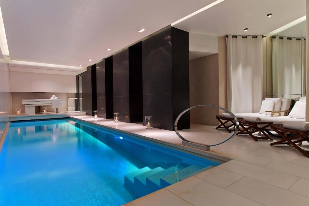 una gran piscina en una habitación de hotel en Le Metropolitan Paris Tour Eiffel, a Tribute Portfolio Hotel, en París