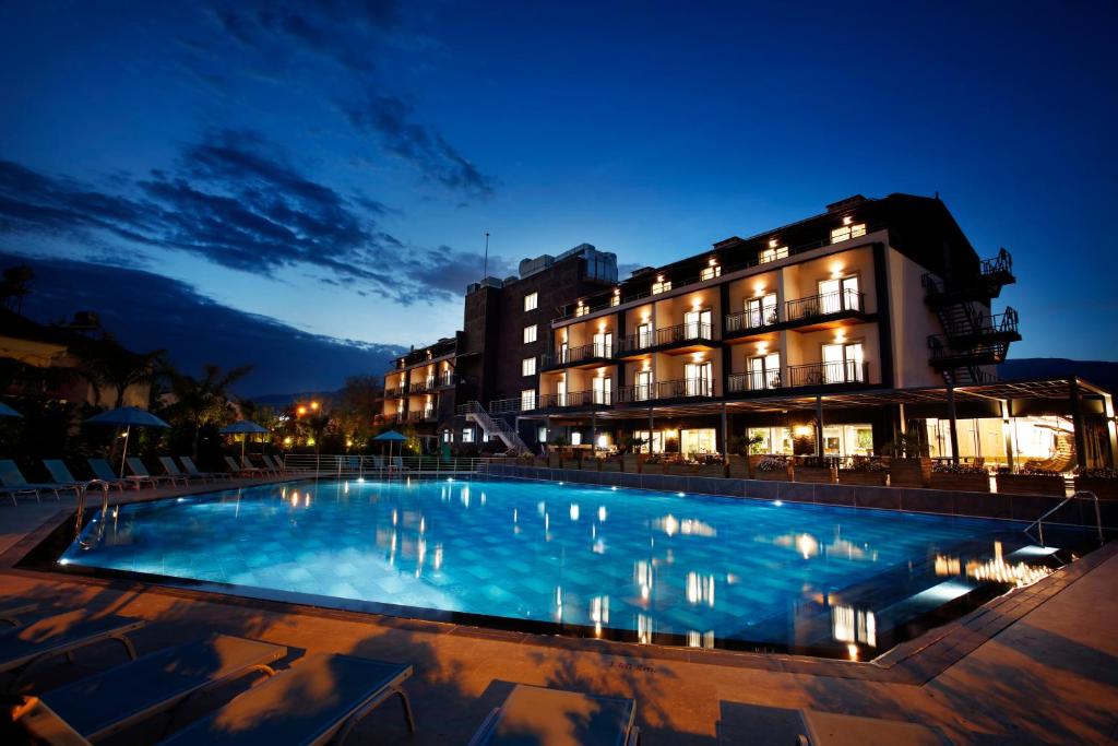 a swimming pool in front of a building at night at Kazdağları Allia Thermal Health & Spa in Edremit