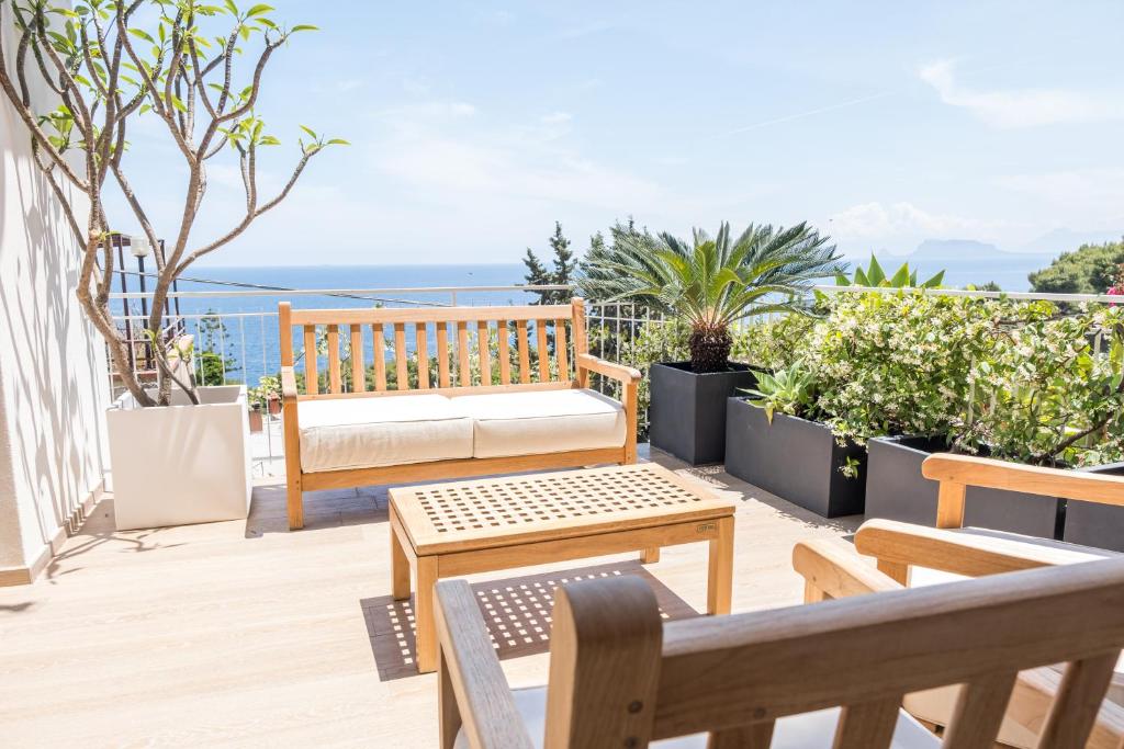 a patio with a bench and tables on a balcony at Teatro Apartments Mondello in Palermo