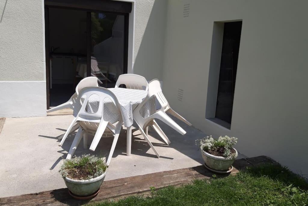a white table and chairs sitting next to a building at REZ DE JARDIN AU COEUR DES PYRENEES in Agos-Vidalos