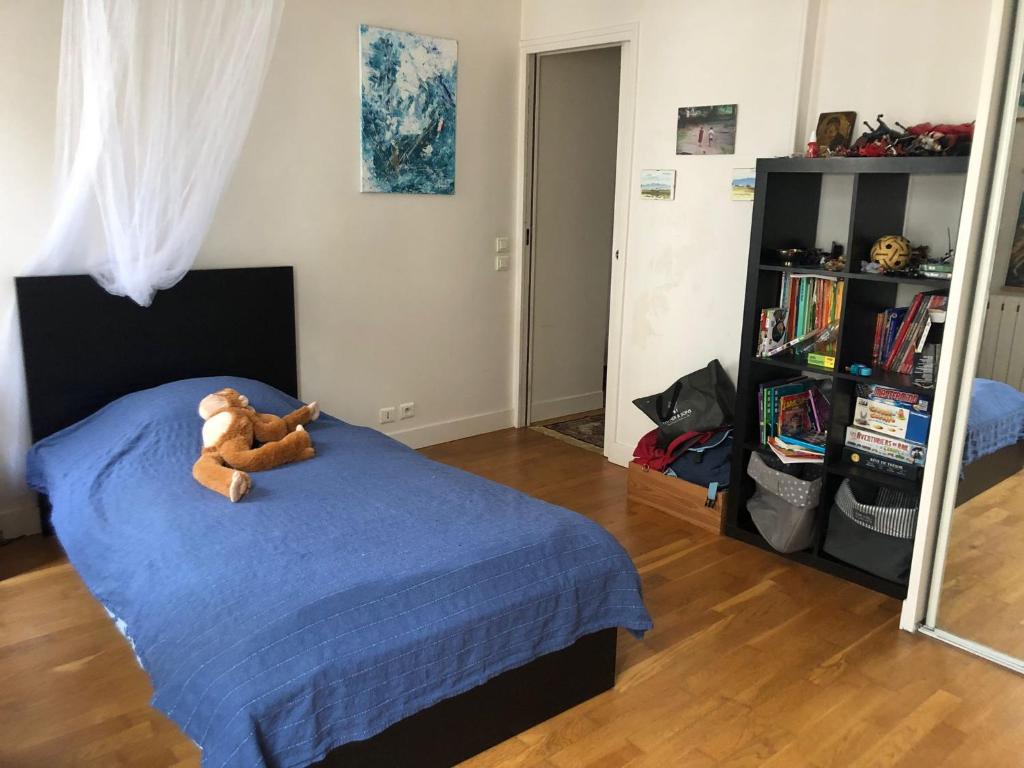 a teddy bear sitting on a bed in a bedroom at Pour la période des Jeux Olympiques 2024 seulement Duplex de 4 chambres à 100 mètres de Paris for Olympics 2024 only 4 bedroom duplex 100 meters from Paris in Montrouge