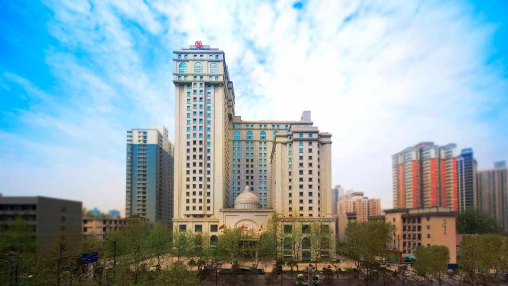 ein großes Gebäude mit einem Uhrturm in einer Stadt in der Unterkunft Sheraton Xi'an North City Hotel in Xi'an