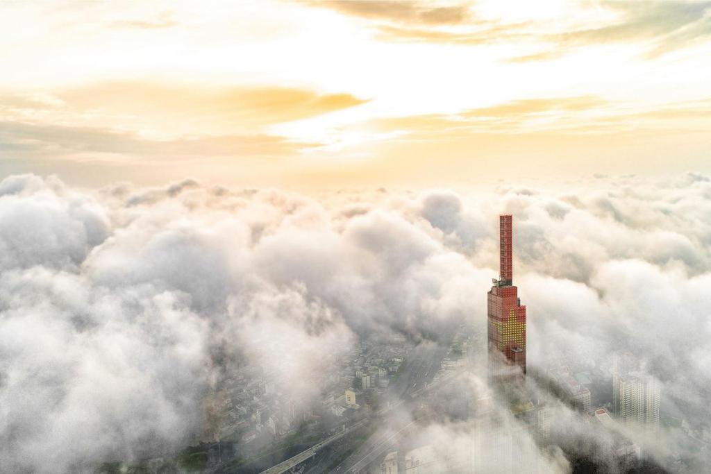 een uitzicht op een wolkenkrabber boven de wolken bij Vinpearl Landmark 81, Autograph Collection in Ho Chi Minh-stad