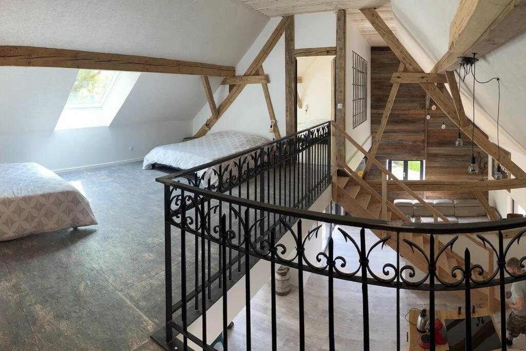a spiral staircase in a room with two beds at Le grenier a foin in Breitenbach-Haut-Rhin
