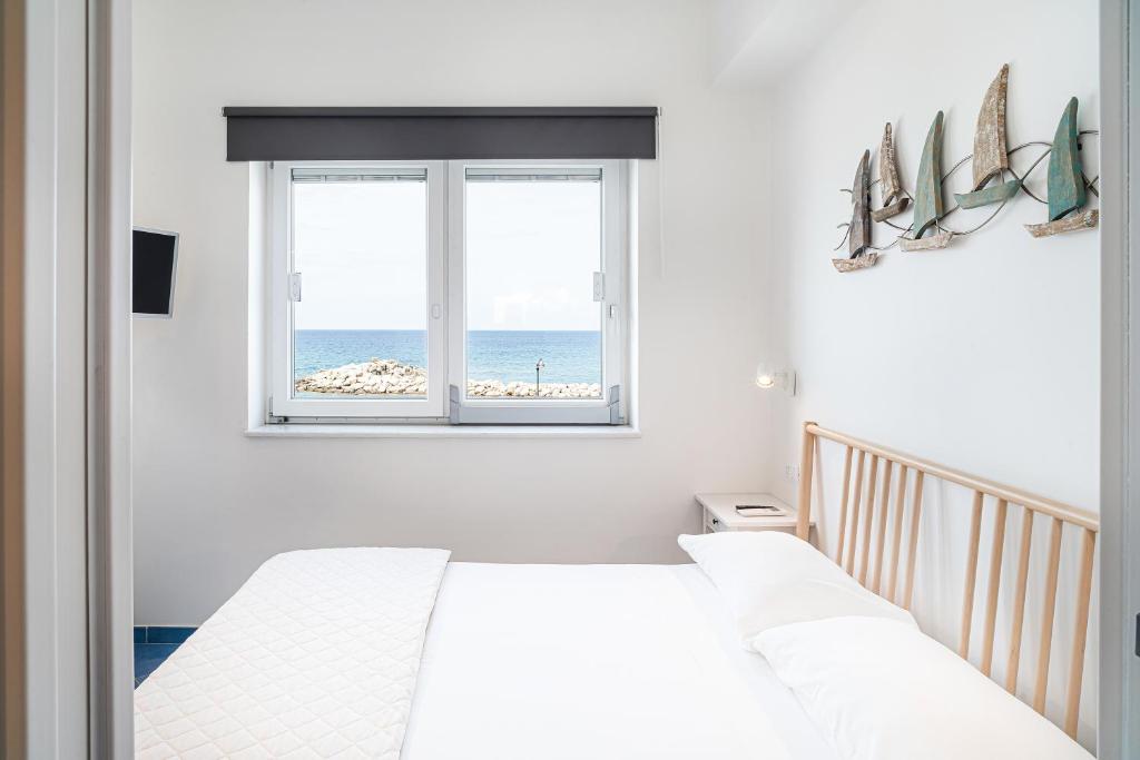 twee bedden in een slaapkamer met uitzicht op de oceaan bij Un Posto al Mare in Santa Maria di Castellabate