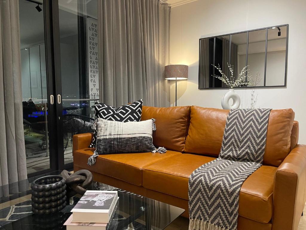 a living room with a brown leather couch at Exec Oasis @Ellipse in Midrand