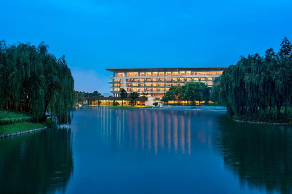 un edificio sentado a un lado de un lago en The Yuluxe Sheshan, Shanghai, A Tribute Portfolio Hotel en Songjiang