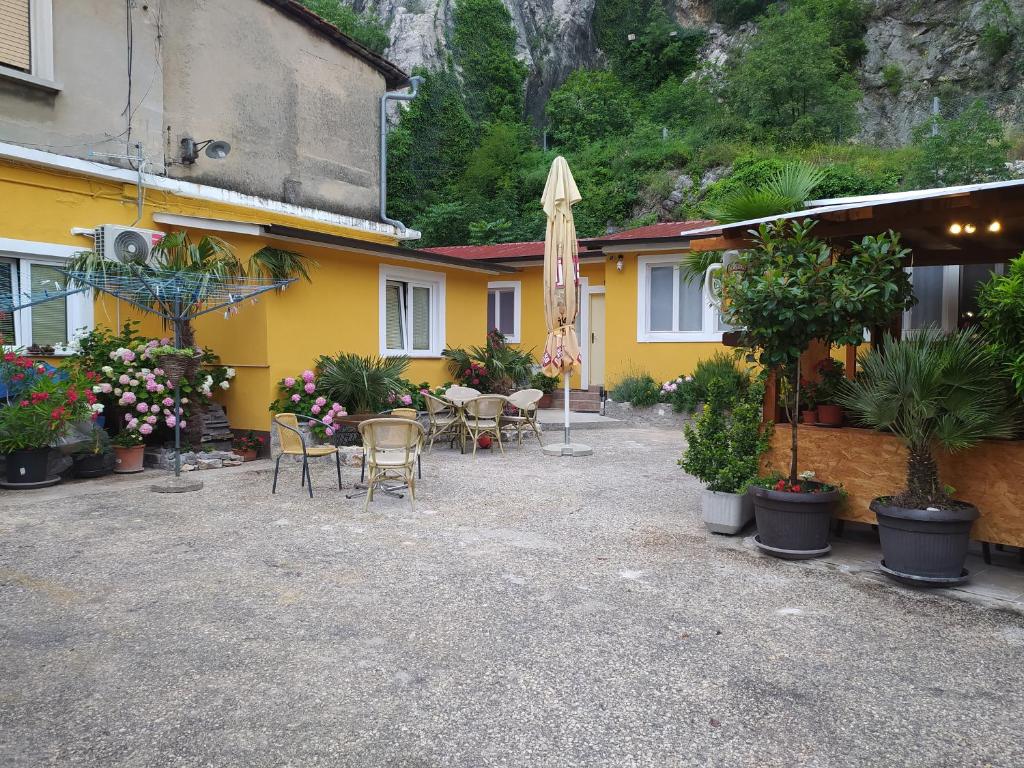 a yellow building with a patio with chairs and plants at IN Kala in Rijeka