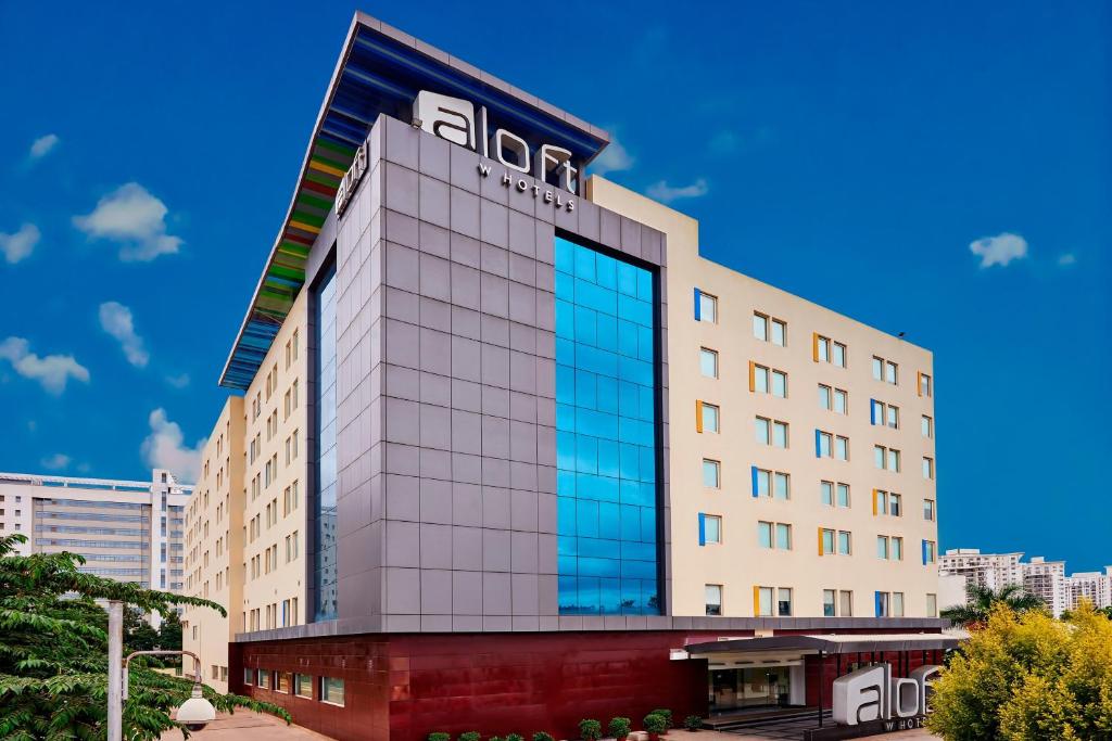 a building with glass windows on the side of it at Aloft Bengaluru Whitefield in Bangalore