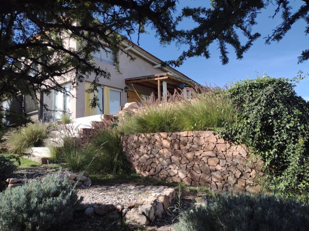 a house with a stone wall in front of it at LOFT DE MONTAÑA -LaS RABONAS - PISCINA EXCLUSIVA in Las Rabonas