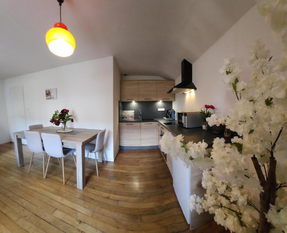 cocina y comedor con mesa y sillas en Gite Myrtille 2 à 6 personnes dans Residence des Buis avec Spa en Ventron