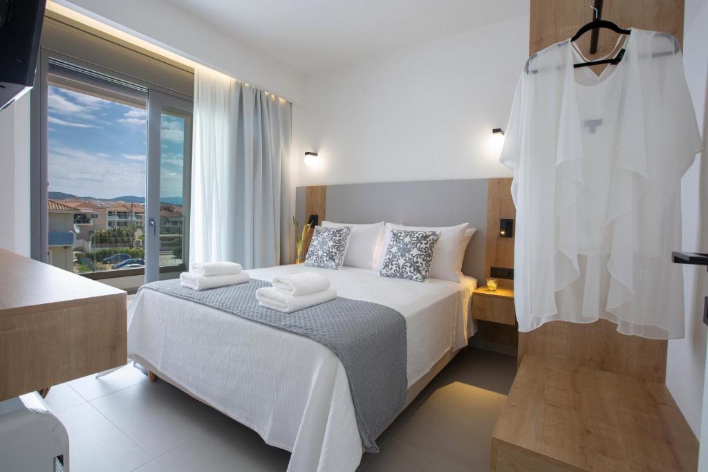 a bedroom with a bed and a large window at Achillion Suites in Lefkada Town