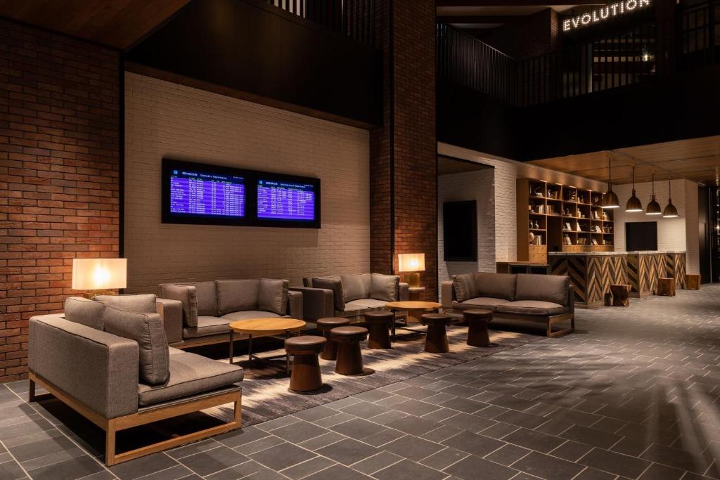 Four Points by Sheraton Nagoya, Chubu International Airport في Tokoname: لوبي فيه كنب وطاولات ونافذة