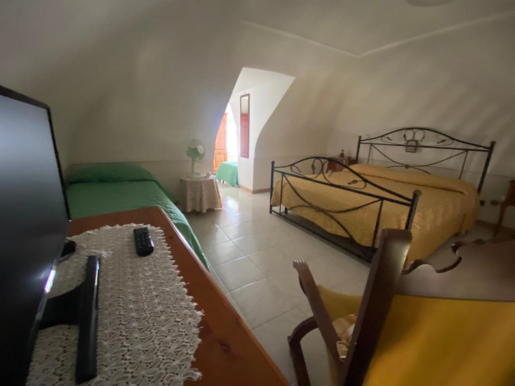 sypialnia z 2 łóżkami i stołem w pokoju w obiekcie La Casa dei Sogni w mieście Procida