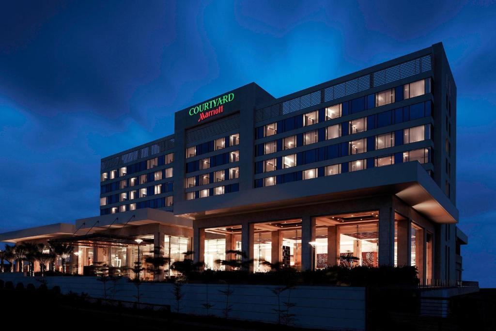a hotel with a lit up building at night at Courtyard by Marriott Pune Chakan in Chakan