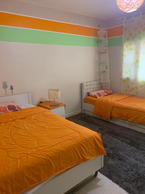 a bedroom with two beds with orange sheets at Ajloun 2 bedrooms apartment in Ajloun