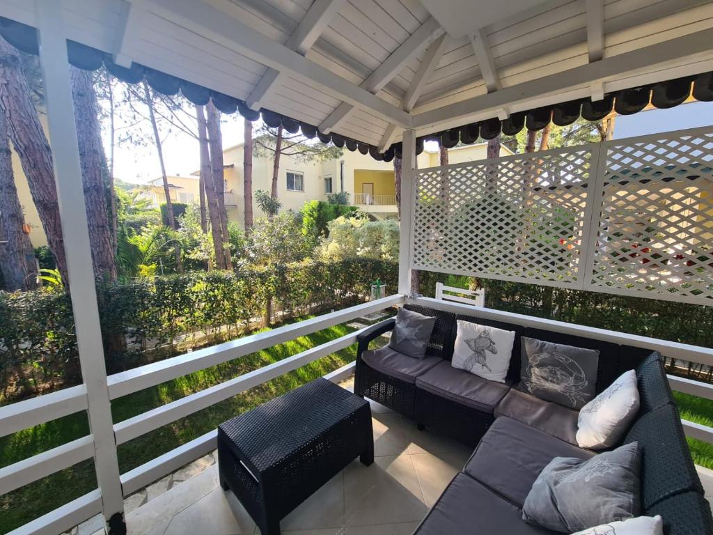 een afgeschermde veranda met een bank en stoelen bij Apartamento Famiglia vacanza in Mullini i Danit